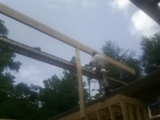 Carpenter setting a ridge beam over a new addition frame — Ice Dam Removal by Roofing Brothers in Chicora