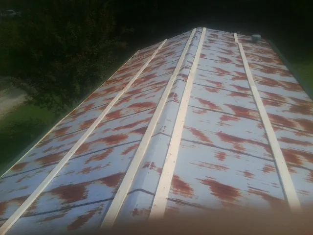 Rusted metal roof panels with new wood purlins before replacement — Storm Damage Roof Repair in Chicora by Roofing Brothers