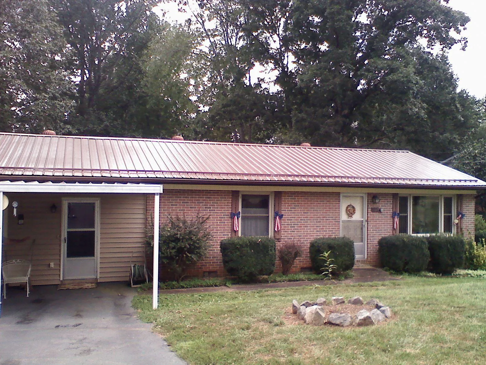 Bronze metal roof and carport on a brick ranch home — Roof Repair work by our crew in Chicora