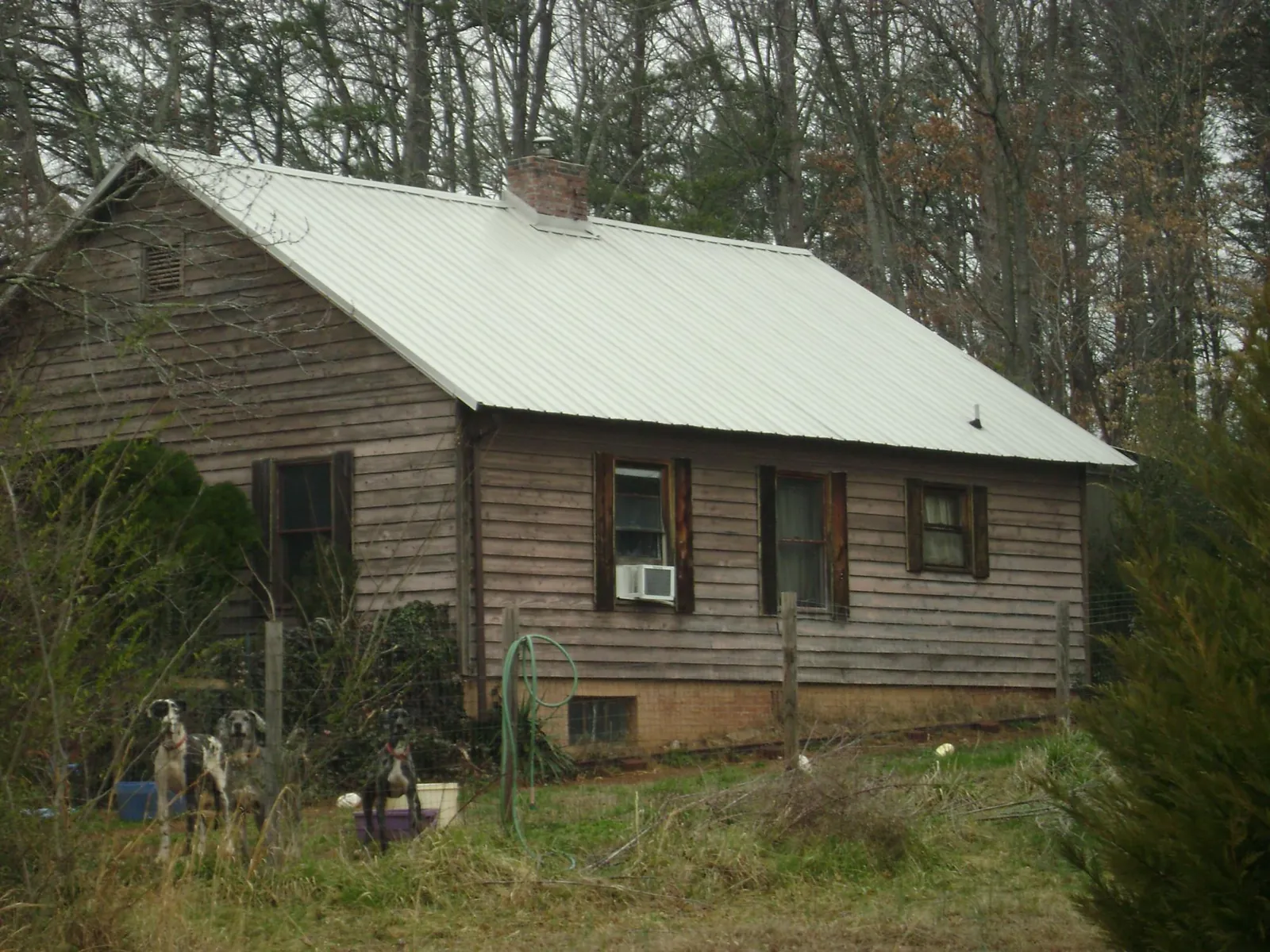 White metal roof on an old wood sided farmhouse, from a Metal Roof Installation job in Chicora